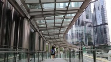 Hong Kong - 18 Ağustos 2024: Kapalı yaya köprüsünden geçenler, HK