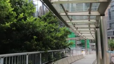 Hong Kong - 18 Ağustos 2024: Kapalı yaya köprüsünden geçenler, HK