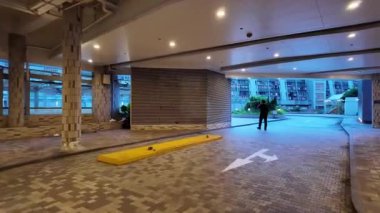 Hong Kong - 29 Ağustos 2024: Parlak renkli otoparkta ve apartmanda yürüyen adam