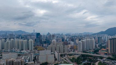 Bulutlu gökdelenlerin altında yükselen şehir manzarası,