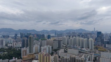 Bulutlu gökdelenlerin altında yükselen şehir manzarası,