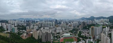 Bulutlu gökdelenlerin altında yükselen şehir manzarası,