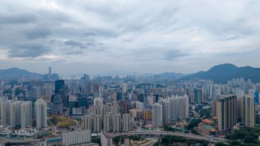 Bulutlu gökdelenlerin altında yükselen şehir manzarası,