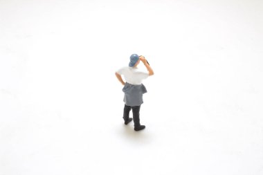 Günlük kıyafetlerinde içecek olan bir adamın figürlü oyuncağı.