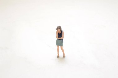 Bir kadın figürü düşünceli bir şekilde ayakta duruyor.