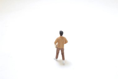 Minyatür figür, düz bir alana kurulmuş bir karton kutu tutarken resmedilir.