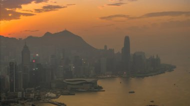 5 Ocak 2025, sıcak günbatımı renkleriyle örtülmüş hareketli bir şehrin gökyüzü manzarası,