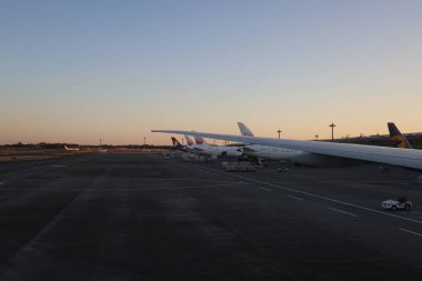 Gün doğumunda 3 Aralık 2024 havaalanı pisti, bir uçak kanadı ve pist planı sergileniyor..