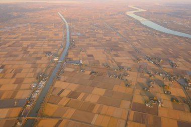 Dec 3 2024 Expansive aerial view showing a structured mosaic of farmland fields arranged near waterways clipart