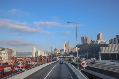 3 Aralık 2024 yolu altında park halindeki vinçlerin bulunduğu bir kargo limanından geçiyor.