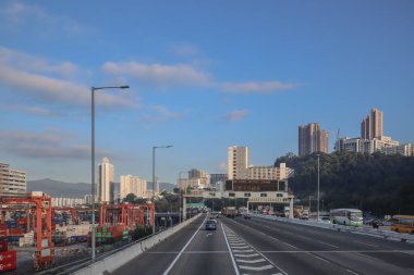 3 Aralık 2024 yolu altında park halindeki vinçlerin bulunduğu bir kargo limanından geçiyor.