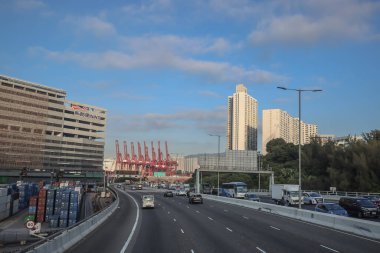 3 Aralık 2024 yolu altında park halindeki vinçlerin bulunduğu bir kargo limanından geçiyor.