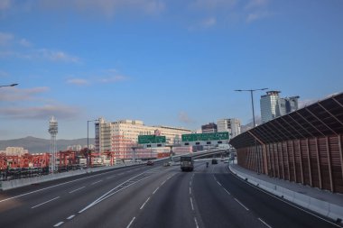 3 Aralık 2024 yolu altında park halindeki vinçlerin bulunduğu bir kargo limanından geçiyor.