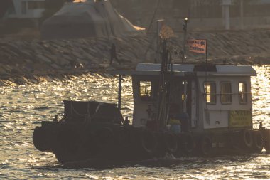 Günbatımında Balıkçı Teknesi Rocky Shoreline 'ın yanında Yansımalar Ocak 11 2025