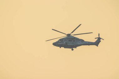 Helikopter Orange Sunset Sky 'ın üzerinden uçuyor. 11 Ocak 2025
