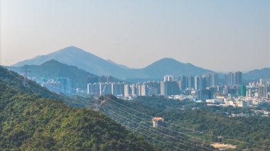 Yeşil tepelere karşı modern bir siluet oluşturan 11 Ocak 2025 şehir manzarası