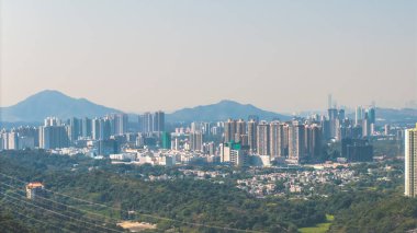 Yeşil tepelere karşı modern bir siluet oluşturan 11 Ocak 2025 şehir manzarası