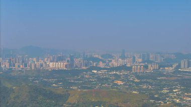 Yeşil tepelere karşı modern bir siluet oluşturan 11 Ocak 2025 şehir manzarası