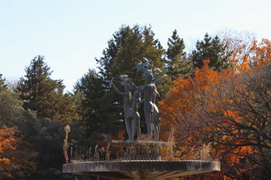 Ağaç yaprakları gölgelere karşı canlı bir şekilde duruyor.