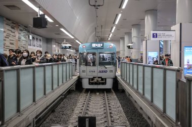 Dec 4 2024 subway station capturing an arriving train surrounded by numerous passengers clipart