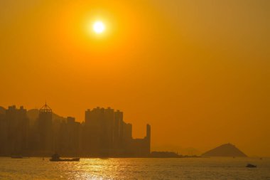 19 Ocak 2025 hareketli bir şehrin silueti parlayan bir portakala karşı gökyüzü