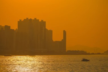 19 Ocak 2025 hareketli bir şehrin silueti parlayan bir portakala karşı gökyüzü