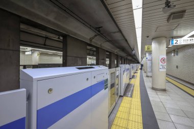 5 Aralık 2024 'te mavi bir tren, güvenlik bariyerleri ve yön işaretlerinin yanında durdu.,