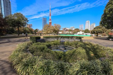 Pırıl pırıl camdan bir gökdelen ve 5 Aralık 2024 tarihli şehir parkına ev sahipliği yapan şehir manzarası