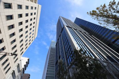 5 Aralık 2024 Modern gökdelenler mavi gökyüzüne doğru uzanıyor,