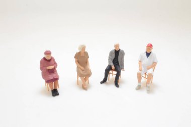 Çemberde oturan bireylerin minyatür figürleri,