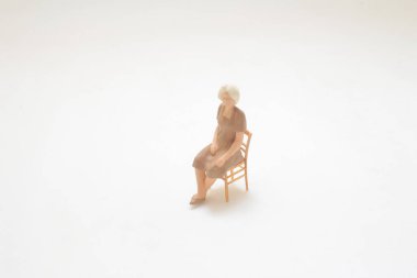 Sandalyede dinlenen bir kadını temsil eden minyatür bir heykel.