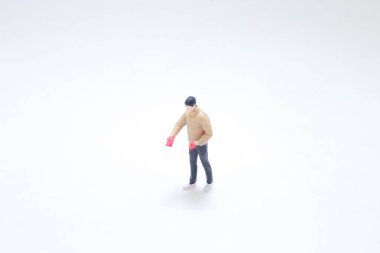 Dik duran, eldiven takan küçük bir heykel.,