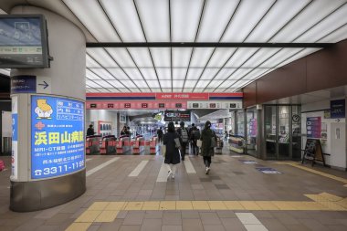 4 Aralık 2024 Yürüyen merdivenler, reklamlar ve müşterilerin yer aldığı hareketli bir alışveriş merkezi.