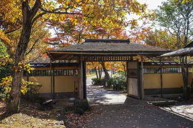 4 Aralık 2024 Japon kapısı huzurlu bir bahçede canlı sonbahar ağaçlarıyla çevrili.