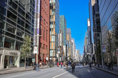 7 Aralık 2024 Modern binalarla çevrili geniş bir caddeye sahip canlı şehir manzarası