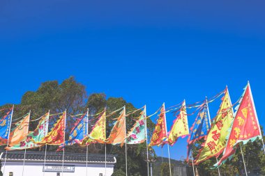 Jan 29 2025 Brightly colored flags wave against a clear blue sky, clipart