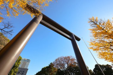 Silhouetted people walk under a Torii gate surrounded by golden autumn Dec 7 2024 clipart