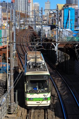 6 Aralık 2024, modern şehirlerle çevrili hareketli bir bölgede raylar üzerinde seyahat ediyor.