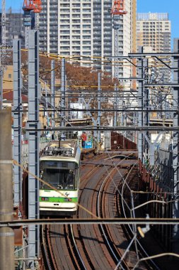6 Aralık 2024, modern şehirlerle çevrili hareketli bir bölgede raylar üzerinde seyahat ediyor.