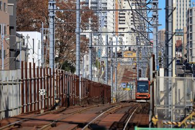 6 Aralık 2024, modern şehirlerle çevrili hareketli bir bölgede raylar üzerinde seyahat ediyor.