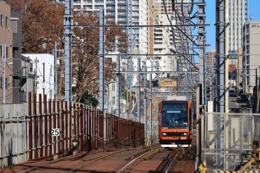 6 Aralık 2024, modern şehirlerle çevrili hareketli bir bölgede raylar üzerinde seyahat ediyor.