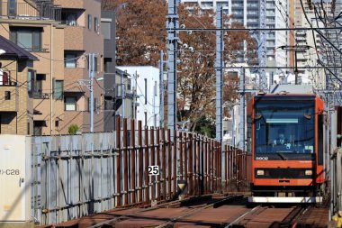 6 Aralık 2024, modern şehirlerle çevrili hareketli bir bölgede raylar üzerinde seyahat ediyor.