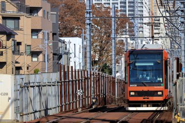 6 Aralık 2024, modern şehirlerle çevrili hareketli bir bölgede raylar üzerinde seyahat ediyor.