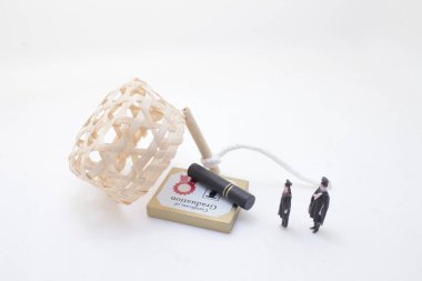 Küçük mezunların, bir sertifikanın ve sanatsal objelerin yer aldığı tuhaf bir sahne.,