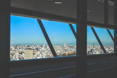 9 Aralık 2024 Modern bir şehir manzarası büyük pencerelerden görülür, kenti yakalar