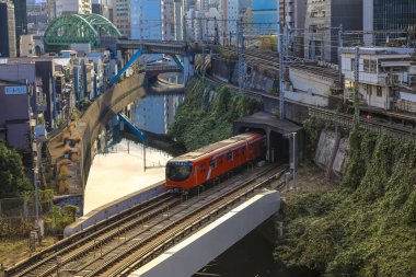 8 Aralık 2024 treni şehir binalarıyla çevrili bir kanalın yanındaki köprüden geçiyor.