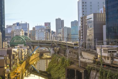 8 Aralık 2024 treni şehir binalarıyla çevrili bir kanalın yanındaki köprüden geçiyor.