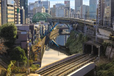 8 Aralık 2024 treni şehir binalarıyla çevrili bir kanalın yanındaki köprüden geçiyor.