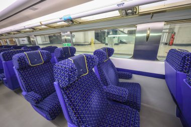 23 Ocak 2025 Kolçaklı mavi koltuklu modern bir tren.,
