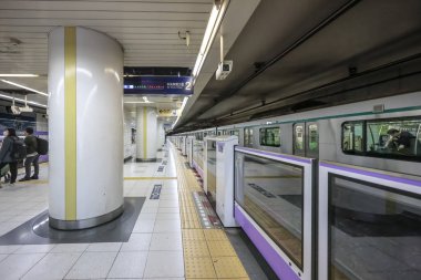 8 Aralık 2024 Parlak ışıklandırılmış metro istasyonu platformu Otomatikleştirilmiş bir tren gösteriyor